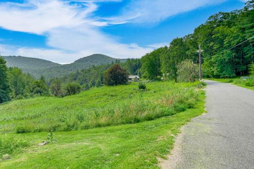 an empty road in the middle of a green field at Hawley Home with Deck and Mtn Views Swim, Ski and More! in Hawley