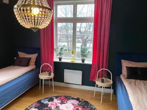 a bedroom with a bed and two tables and a chandelier at Strandvillan Gnesta in Gnesta