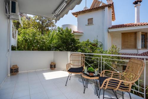 a balcony with two chairs and a fence at Villa Costa Luca in Vouliagmeni in Athens