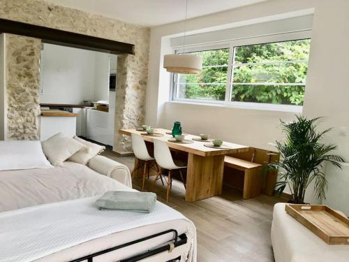 Un dormitorio con una cama y una mesa y un comedor. en Maison proche Disney & Paris, en Lagny