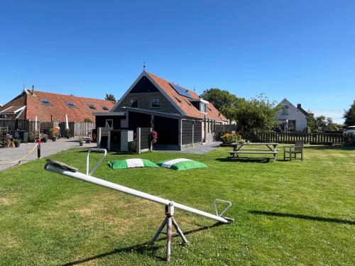 a baseball bat on the grass in front of a house at De Bakkerij in Baaiduinen