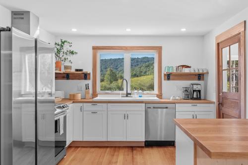 a kitchen with white cabinets and a window at Chambers Hollow in Walton