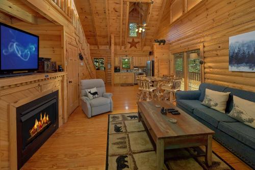 a living room with a fireplace in a log cabin at Camp Cozy in Pigeon Forge