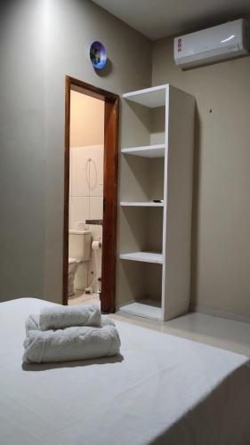 a bedroom with a bed and a open closet at Pousada Canto Verde in Barreirinhas