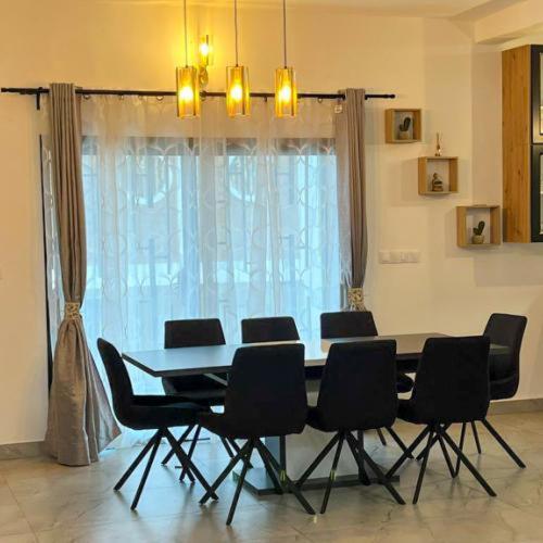 a table and chairs in a room with a window at Résidences LELYSSE in Méyo