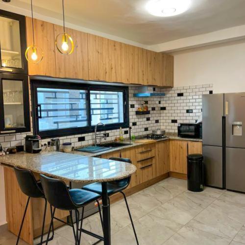 a kitchen with a table and a refrigerator at Résidences LELYSSE in Méyo