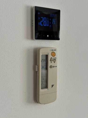a remote control attached to a wall with a clock at Moldovei 2 Apartments by Central Park in Cluj-Napoca