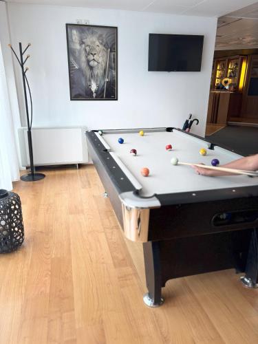 un homme jouant au billard dans le salon dans l'établissement Hôtel Le Valois, Cognac Centre, à Cognac