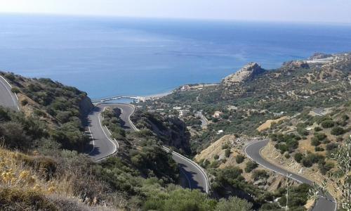 a winding road on the side of a mountain with the ocean at Jason Rooms & Studios in Keratokampos