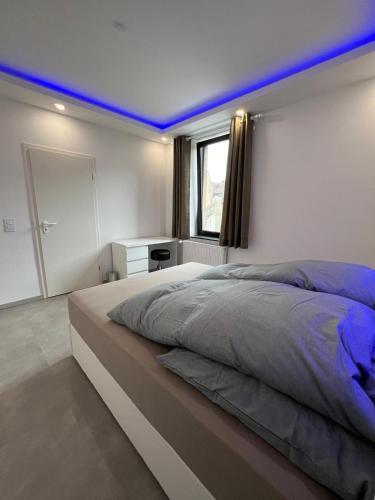 a bedroom with a large bed with a blue lighting at Schöne Mitte von Oberhausen in Oberhausen