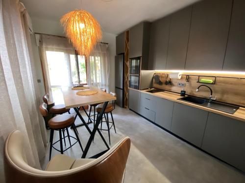 a kitchen with a table and some chairs in it at ELiFourka - Seaside Luxury - 170m to the Beach - Power Onsite for Electric Vehicle in Skála Foúrkas