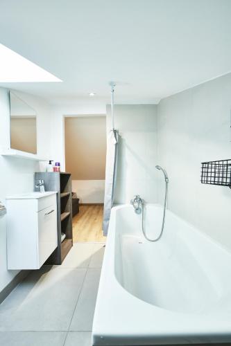 une salle de bain avec une baignoire blanche et un lavabo dans l'établissement RS-4 Studio dans les combles 1 pers - 4ème étage, à Mulhouse