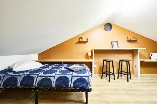 - une chambre avec un lit et un bureau avec des tabourets dans l'établissement RS-4 Studio dans les combles 1 pers - 4ème étage, à Mulhouse