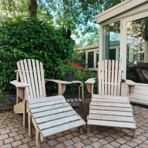 two wooden chairs and a table on a patio at Tuinkamer 't Strunerke in Augustinusga