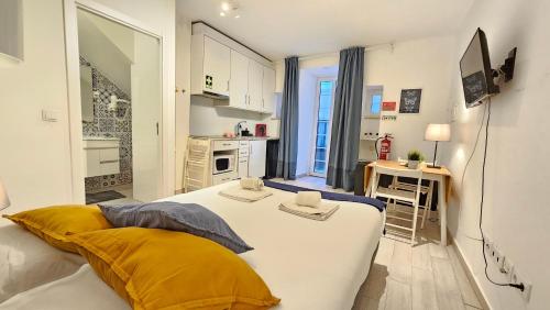 a bedroom with a large bed and a kitchen at BmyT - The Villa in Lisbon