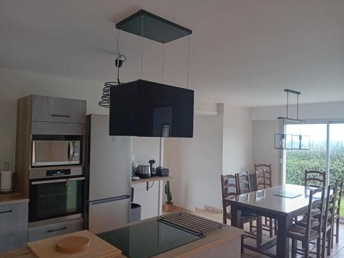 une cuisine avec une table et une salle à manger dans l'établissement Trouz ar mor, à Plonévez-Porzay