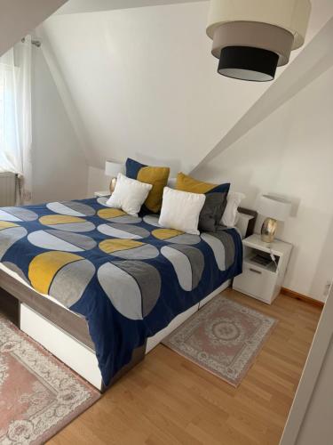 - une chambre avec un lit doté d'une couette bleue et jaune dans l'établissement villa grand standing pour- Basse Normandie - calme dans un cadre verdoyant, à Aubusson