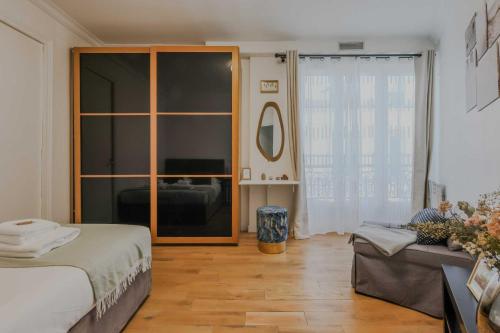 une chambre avec un lit et un canapé dans l'établissement Charming apartment - 1BD-4P - Gare du Nord, à Paris
