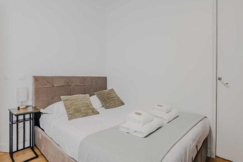une chambre avec un lit blanc avec des serviettes dessus dans l'établissement Charming apartment - 1BD-4P - Gare du Nord, à Paris
