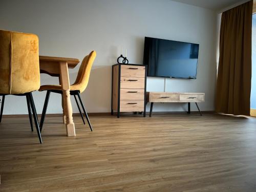 a living room with a television and a desk and chair at Ferienwohnung Sonneck in Oberstaufen
