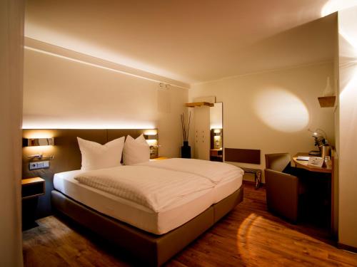 a hotel room with a bed and a desk at Hotel Restaurant Kohlbrecher Villeroy & Boch in Osnabrück