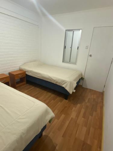 a small room with two beds and a mirror at Arriendos Parra's in Coquimbo