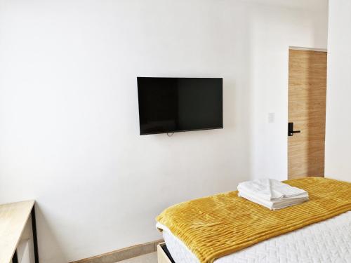 a bedroom with a flat screen tv on the wall at Genial y confortable Cerca de Miraflores, Forum Majadas H11 in El Rodeo