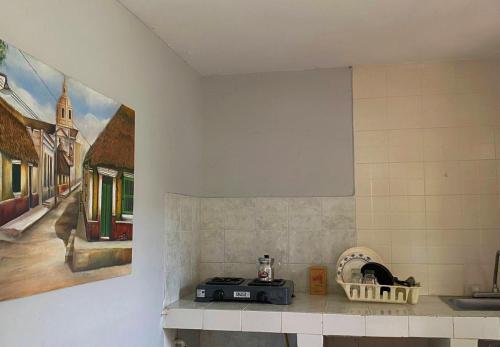 a kitchen counter with a painting on the wall at Hotel Villa Mary Apartaestudios playa in Puerto Colombia