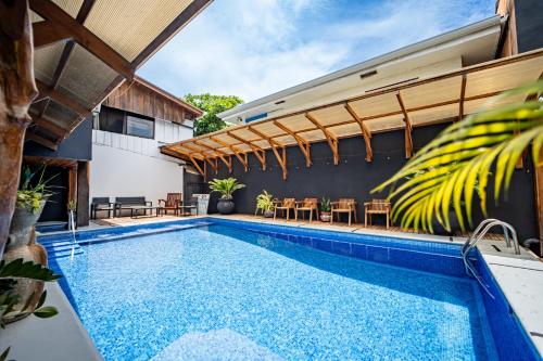 an indoor pool with tables and chairs next to a house at La Flor de Coco in Sámara