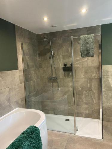 a bathroom with a shower and a bath tub at Cumberland House in Cockermouth