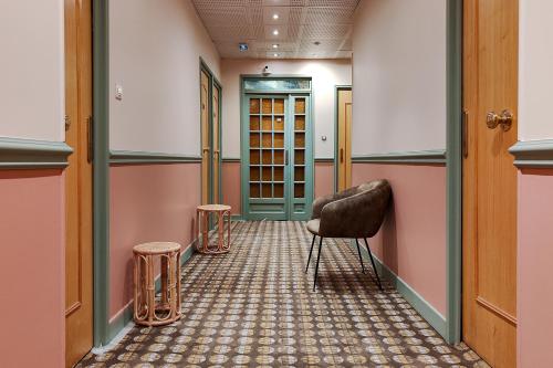 a hallway with a chair and two stools at Aparthotel AMMI Nice Massena - ex Ajoupa in Nice