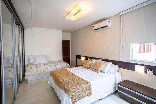 a bedroom with two beds and a window at Casa Jardim - Praia do Bessa por Carpediem in João Pessoa