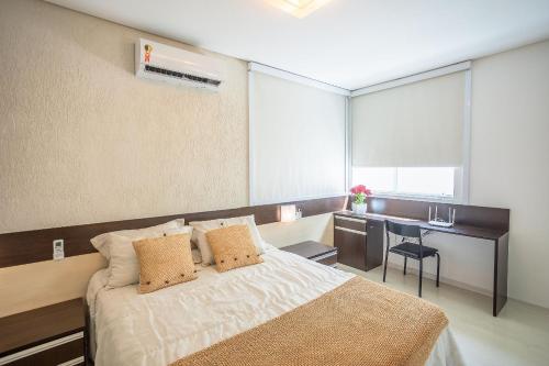 a bedroom with a bed and a desk in it at Casa Jardim - Praia do Bessa por Carpediem in João Pessoa