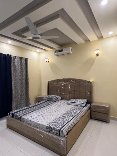 a bed in a room with a ceiling fan at Great Escape in Goth Ali