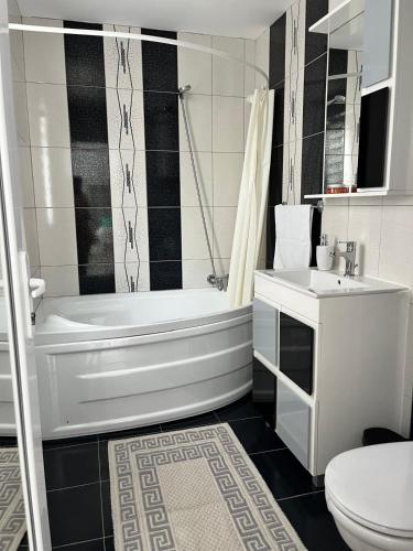 a bathroom with a tub and a toilet and a sink at Casa Angy in Jurilovca