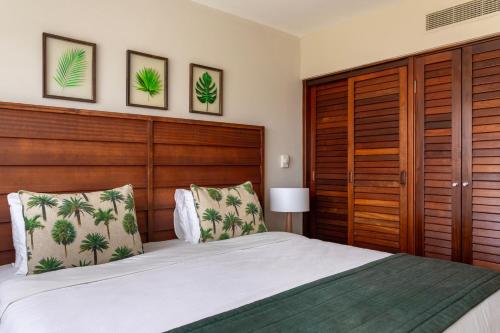 une chambre avec un grand lit avec une tête de lit en bois dans l'établissement Sauipe Brisa Grand Premium All Inclusive, à Costa do Sauipe