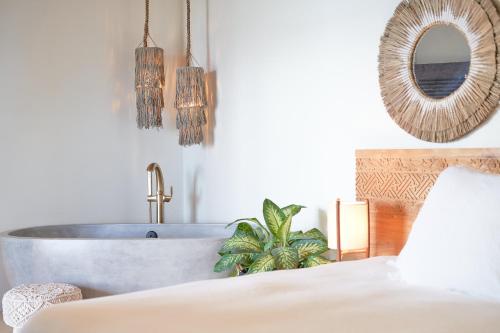 a bedroom with a tub and a bed and a mirror at The Aerial, BVI in Tortola Island