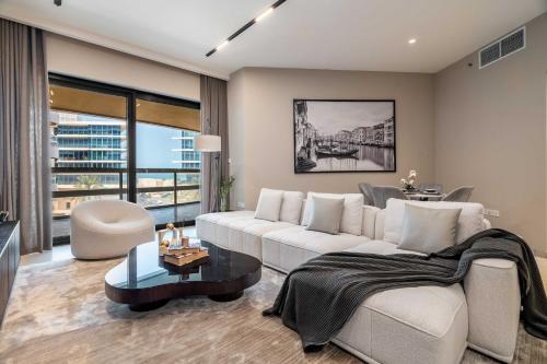 a living room with a white couch and a table at Luxury Saadiyat Soul Beach Residence in Abu Dhabi
