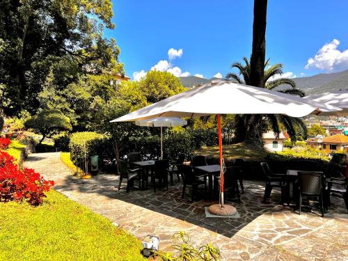 een patio met tafels en stoelen onder een parasol bij Eurotel 405 in Rapallo
