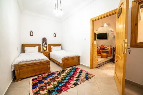 a bedroom with two beds and a mirror and a rug at Authentic Agadir Riad Walk to All Sights in Agadir
