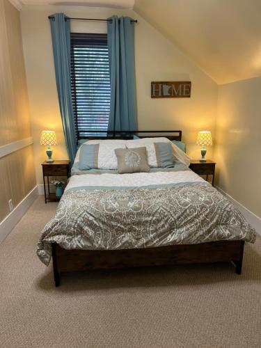a bedroom with a large bed with blue curtains at Over 200' of Shoreline on Foot Lake!! Great Fishing Year Round! in Willmar