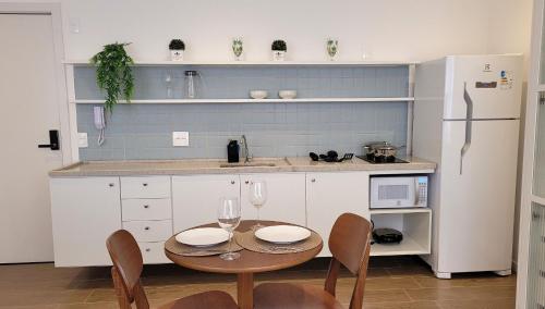a kitchen with a table and chairs and a refrigerator at Blend Coliving One - 2b in Ribeirão Preto