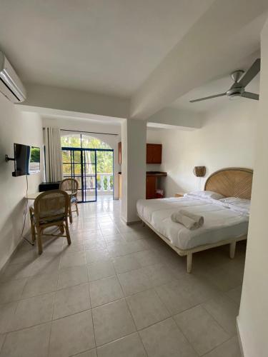 a bedroom with a bed and a table and a chair at El Kaoba in Cabarete