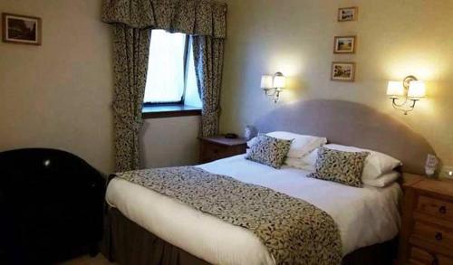 a bedroom with a bed and a window at The Royal Hotel Tain in Tain