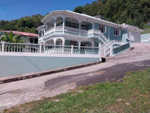 a large blue house with a white balcony at Vacation Getaway at Wallhouse in Loubiere