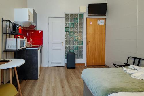 a room with a bed and a table and a kitchen at Aparthotel AMMI Nice Massena - ex Ajoupa in Nice