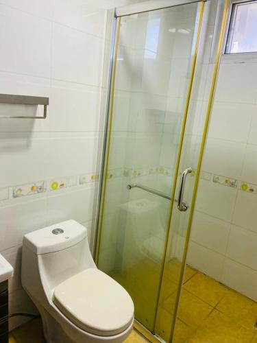 a bathroom with a toilet and a glass shower at Masaki Anne H & Apartment in Dar es Salaam