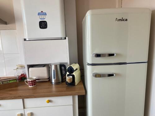 a white refrigerator in a kitchen next to a counter at Appt Ô en Couleurs in Auch