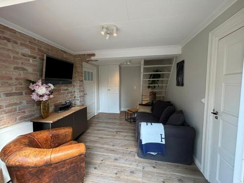 a living room with a couch and a tv at Voorsterstaete former barn, including jacuzzi in Voorst
