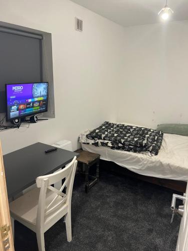 a room with a bed and a desk and a tv at New flat, own bathroom, sitting room & large bedroom - Walsall in Bescot
